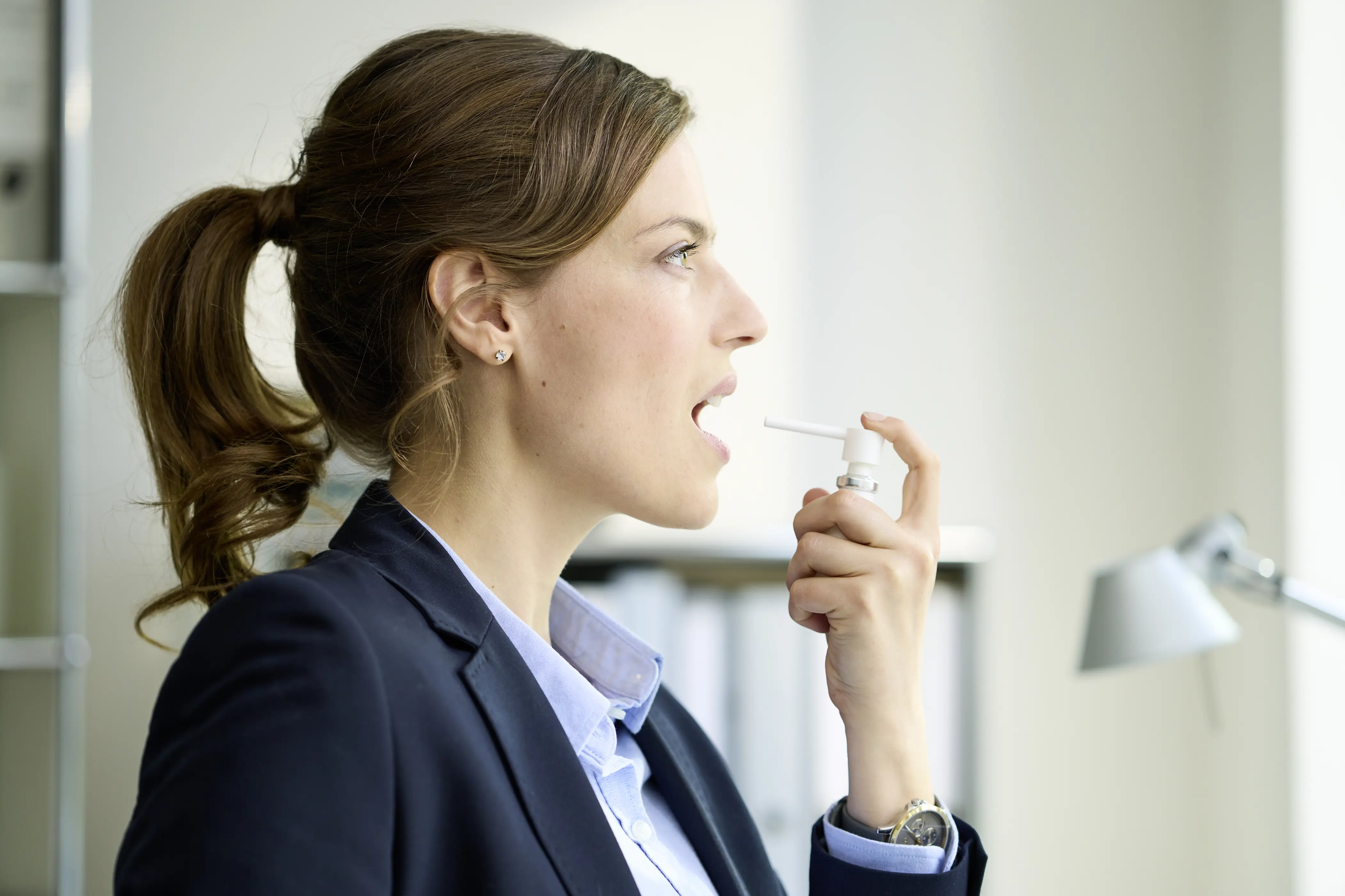 Prijatna-jena-v-biznes-kostjum-praska-Orofar-sprej-v-ustata-si-fon-ofis