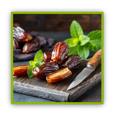 Planche en bois foncé it dattes, menthe et un couteau.